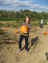 Leah plucks her first pumpkin from the fertile fields